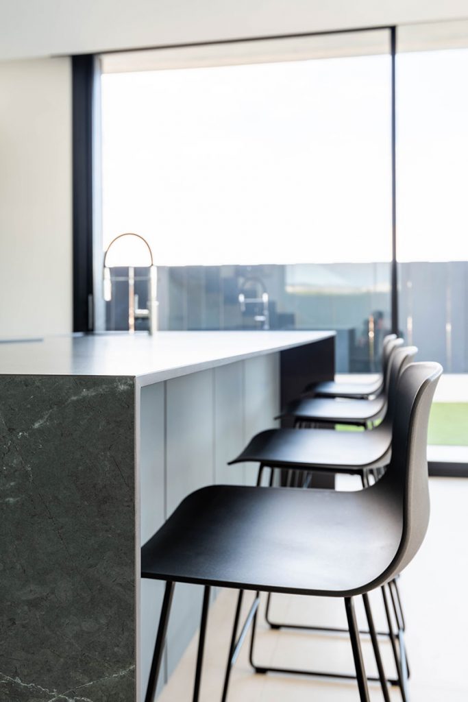 Diseño de cocina con grandes ventanales que conectan el interior con el exterior