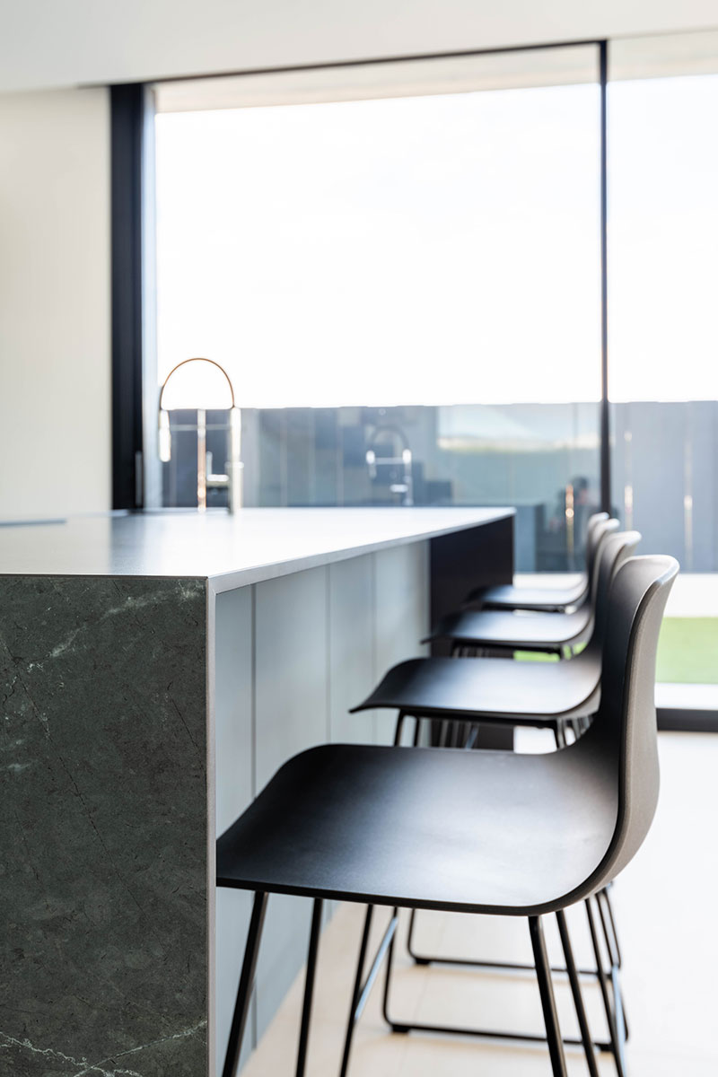 Diseño de cocina con grandes ventanales que conectan el interior con el exterior