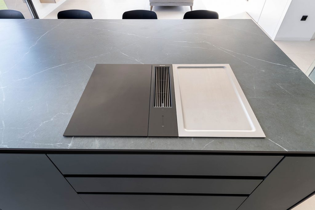 Encimera y fregadero en porcelánico ABK Stone Pietra Grey que ofrecen continuidad al diseño de la cocina con la pared y fachada del jardín