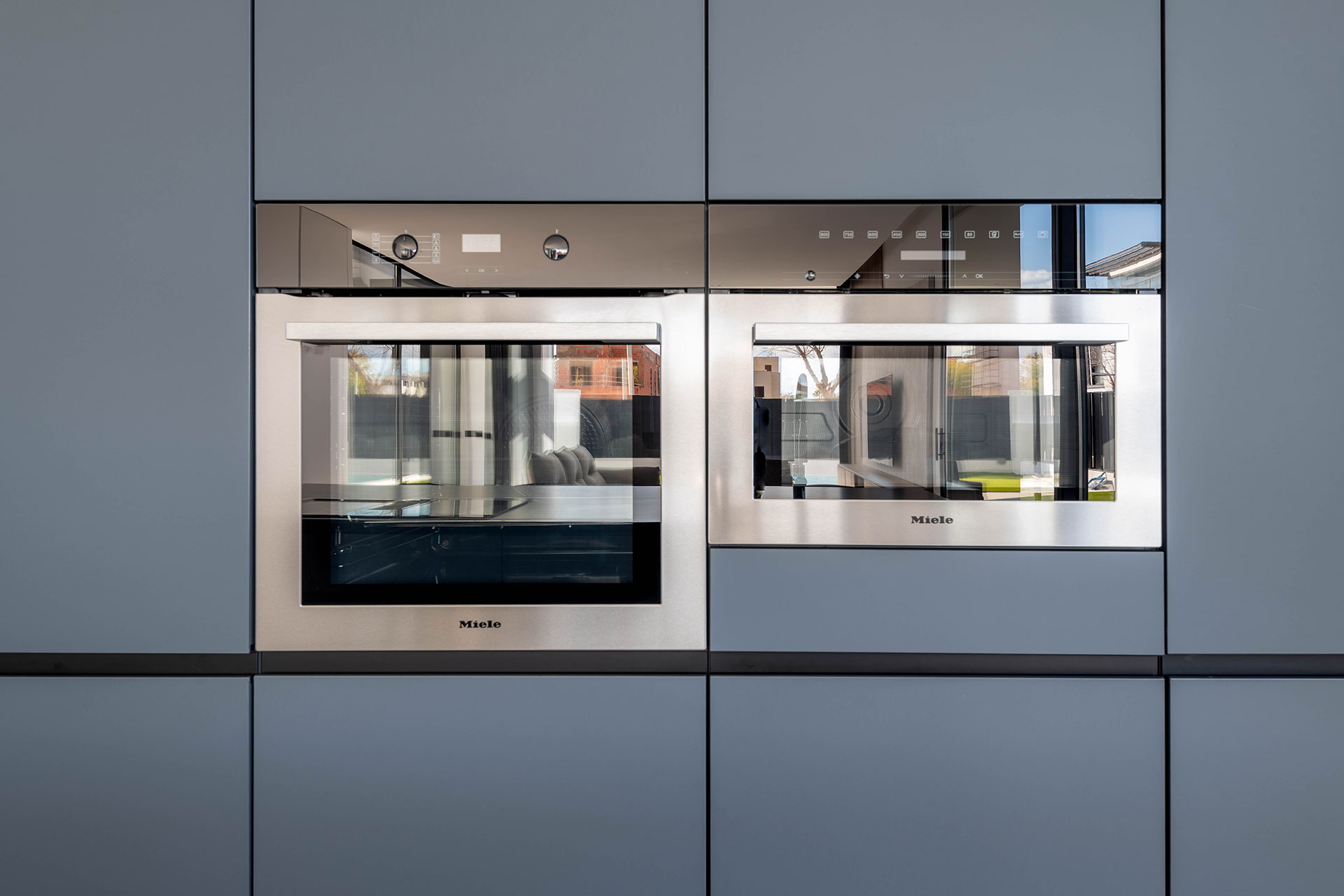 Diseño de cocina útil y práctica con electrodomésticos integrados Miele, horno y microondas en acero para aportar un carácter diferenciador a todo el conjunto.