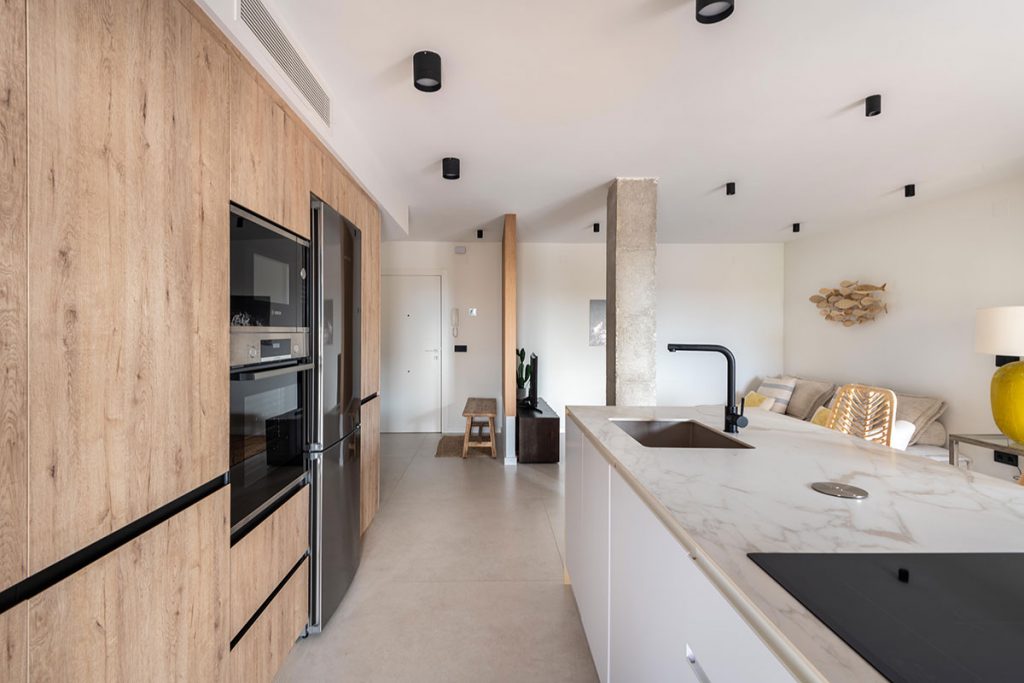 Diseño de cocina pensando en abrazar con muebles los elementos estructurales.