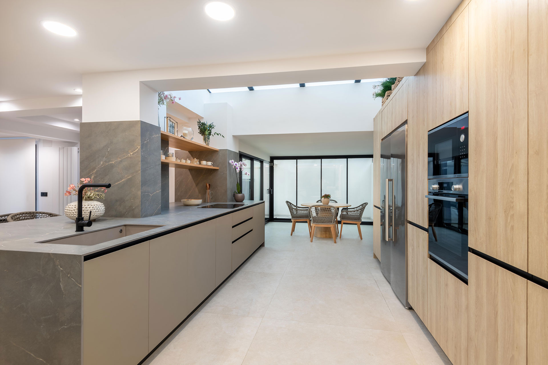 Proyecto de reforma para agrupar distintos espacios, como cocina, barbacoa, y comedor en un único espacio abierto para reuniones de verano.