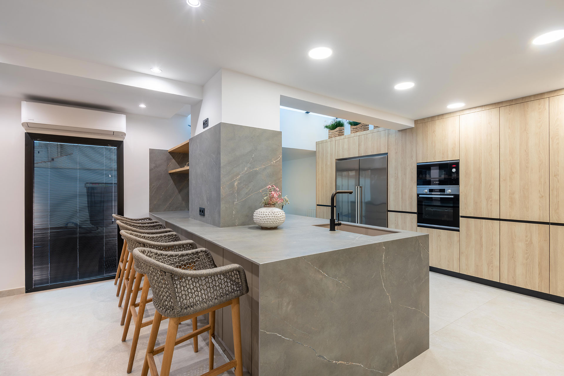 Proyecto de reforma para agrupar distintos espacios, como cocina, barbacoa, y comedor en un único espacio abierto para reuniones de verano.