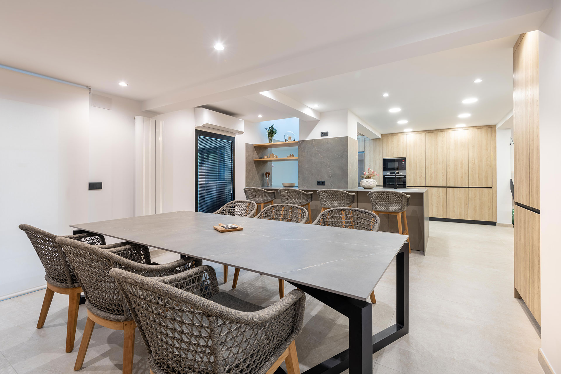 Proyecto de reforma para agrupar distintos espacios, como cocina, barbacoa, y comedor en un único espacio abierto para reuniones de verano.