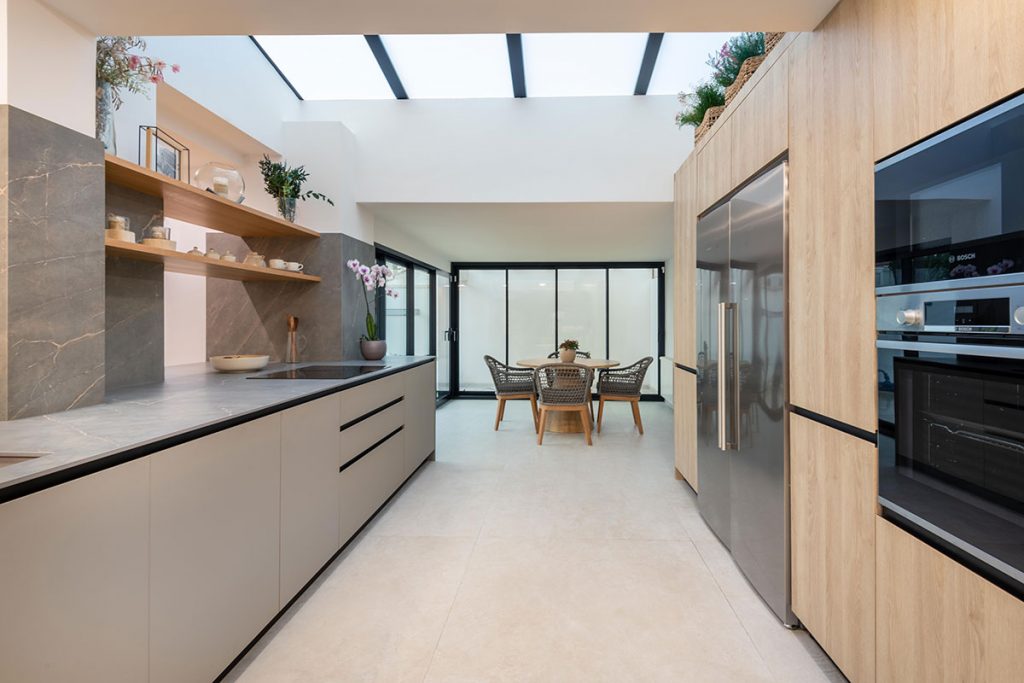 Diseño de cocina integrada con elementos estructurales de espectacular villa, como pilares de carga, vigas y claraboya.