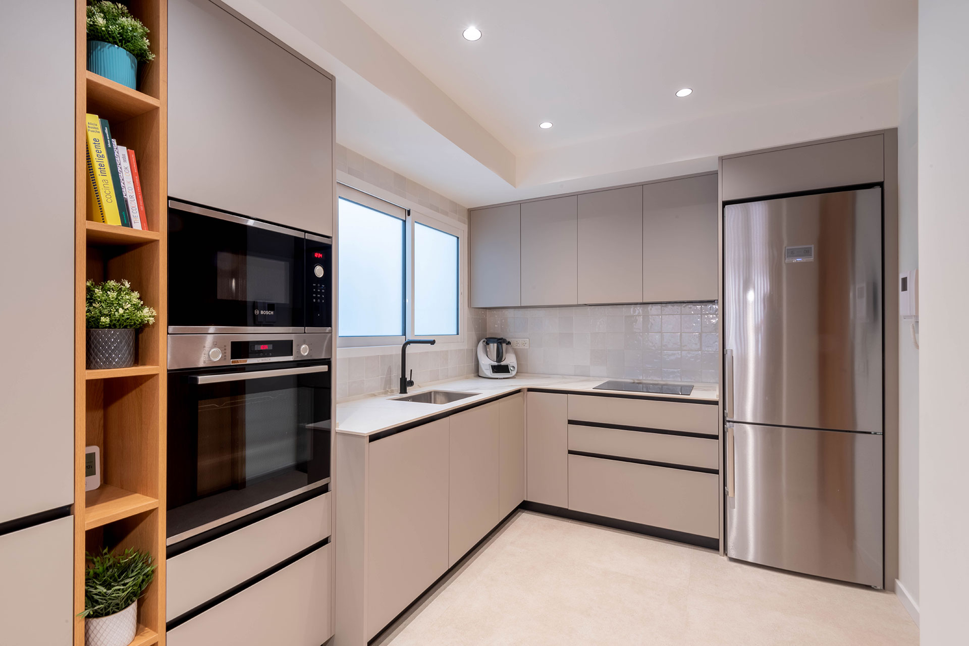 Diseño, fabricación e instalación de cocina con tonos neutros y uniformes, destacando el roble, en vivienda situada en Valencia