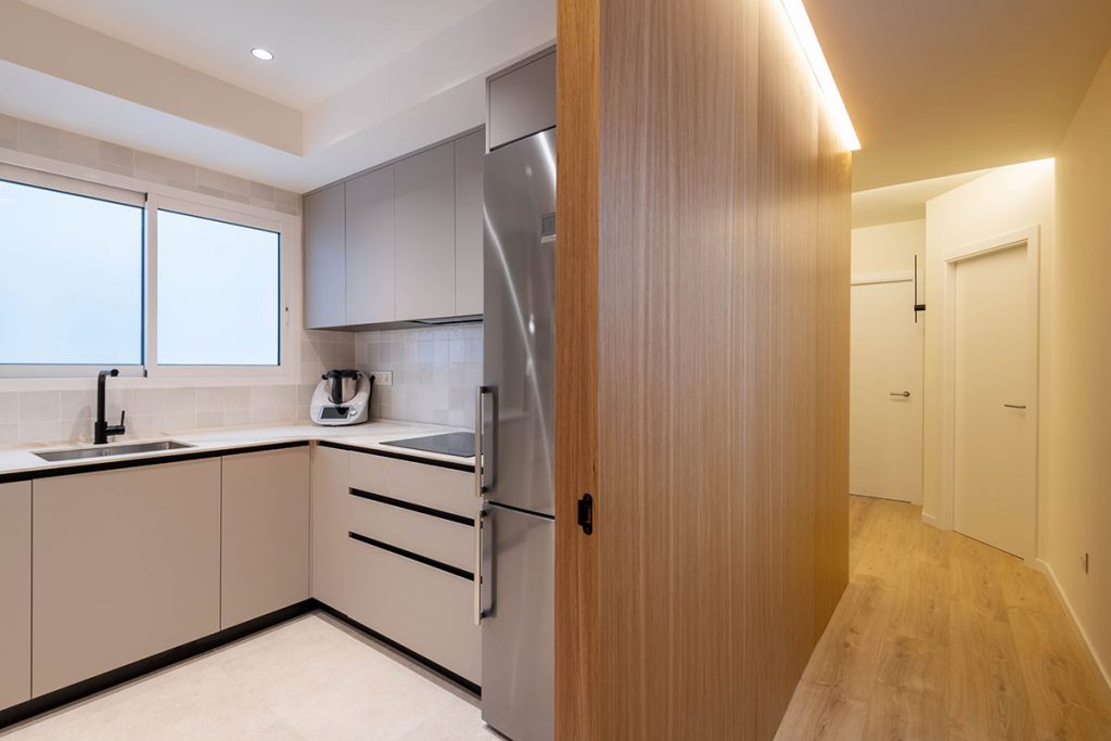 Diseño, fabricación e instalación de cocina con tonos neutros y uniformes, destacando el roble, en vivienda situada en Valencia